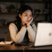 밤에 스탠드를 켜고 노트북을 보며 고민하는 여성의 구글 SEO 걱정