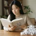 책상에서 책을 읽는 여성과 종이 고리 더미로 보는 콘텐츠 정보의 가치