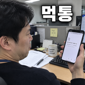 사무실 책상에서 스마트폰 화면을 보며 곤란한 표정을 짓는 남성