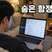 거실 소파에서 노트북으로 워드프레스 플러그인 목록을 확인하는 남성